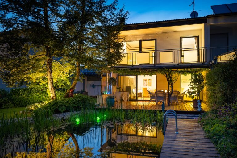 Villa mit Garten und Teich in München am Abend